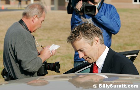 Associated Press photojournalist Ed Reinke (left) scribbles notes as Kentucky Senate candidate Rand Paul gets into a car after voting at Briarwood Elementary School on Tuesday, Nov. 2, 2010 in Bowling Green, Ky.